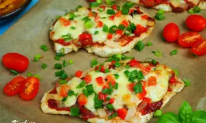 Filet z kurczaka a'la pizza, zapieczony z serem, pomidorami i papryką, posypany szczypiorkiem.