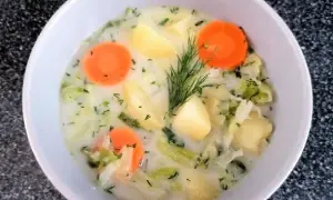 Aksamitna zupa z białej kapusty z ziemniakami i marchewką, ozdobiona koperkiem. Pyszne, domowe danie.