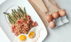 Zielone szparagi w chrupiącym boczku, podane z jajkami sadzonymi i parmezanem. Pyszne danie na śniadanie lub lekki obiad.