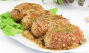 Pyszne mięso z pieczarkami w sosie, podane na liściach sałaty.