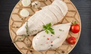 Jak ugotować pierś z kurczaka żeby nie była sucha? Soczysta pierś z kurczaka, jajka przepiórcze, pomidorki i zioła na desce.