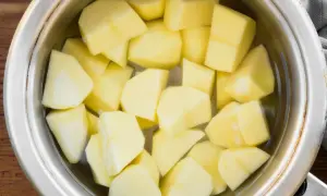 Pokrojone ziemniaki w garnku z wodą, gotowe do ugotowania. To pierwszy krok, jak ugotować ziemniaki na obiad.