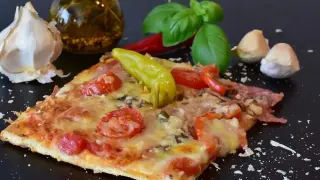 Pyszny kawałek pizzy z pomidorami i papryką, czosnkiem i bazylią. Zastanawiasz się, ile może leżeć pizza w lodówce?