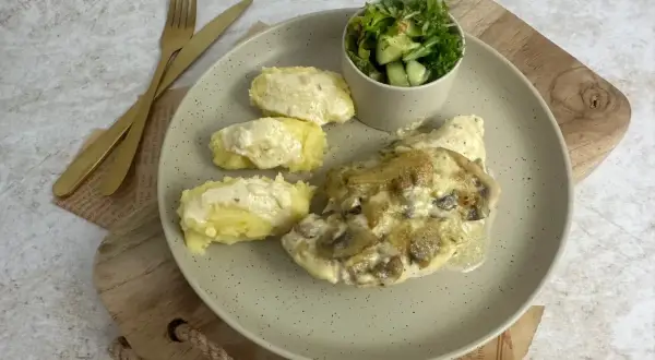 Pyszna pierś z kurczaka w sosie cebulowo-śmietanowym z pieczarkami, podana z puree ziemniaczanym i sałatką.