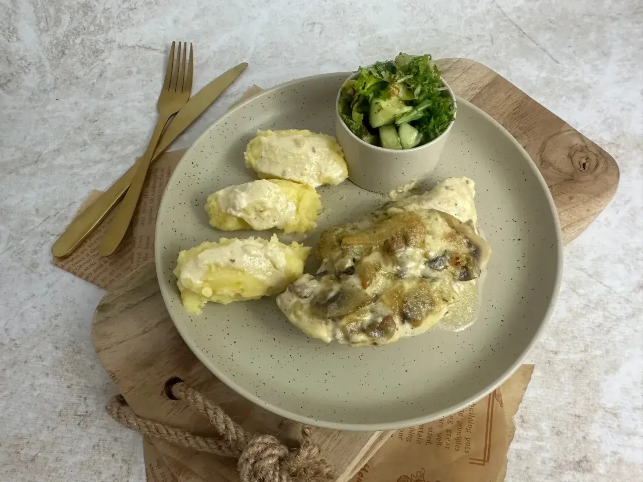Pyszna pierś z kurczaka w sosie cebulowo-śmietanowym z pieczarkami, podana z puree ziemniaczanym i sałatką.