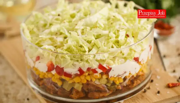 Warstwowa sałatka gyros z mięsem mielonym, kukurydzą, papryką i chrupiącą kapustą pekińską w szklanej misie.