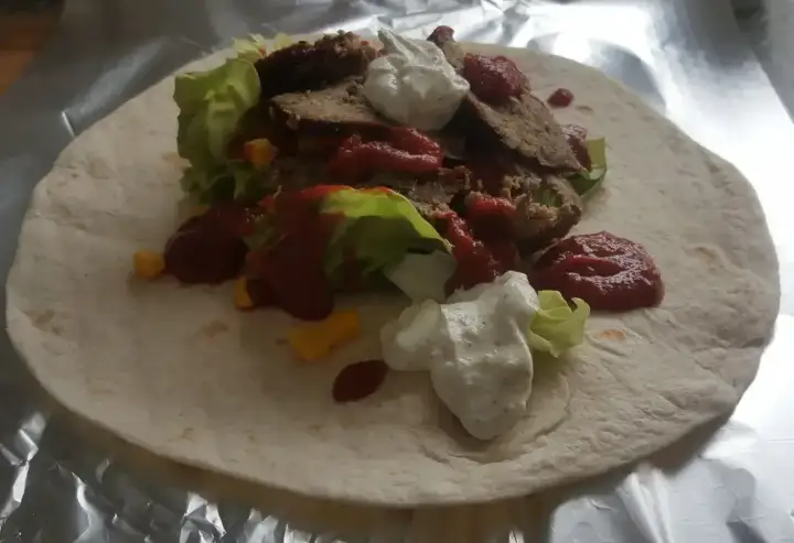 Domowy kebab z baraniną, sałatą, kukurydzą, sosem pomidorowym i jogurtowym na tortilli.